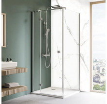 Moderne Dusche mit Glaswänden, Duschkopf und Armaturen in einem hellen Badezimmer.
