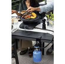 Szene mit Tischgrill beim Grillen von Speisen im Freien.