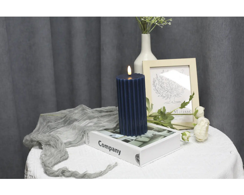 Bougie LED décorative sur une table avec des éléments décoratifs