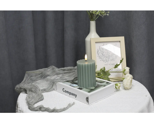 Bougie décorative côtelée sur une table avec des ornements