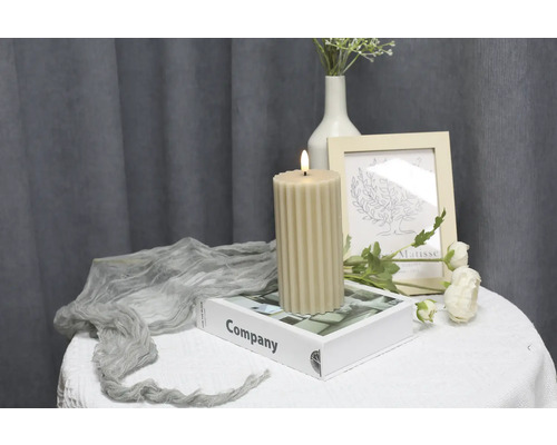 Dekorative geriffelte Kerze auf einem Tisch mit Dekorationen.