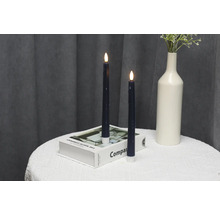 Bougies LED décoratives sur une table avec un livre et un vase