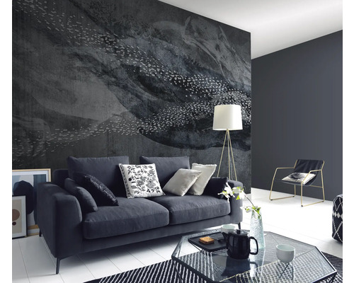 Wohnzimmer mit dunklem Sofa, gemusterter Tapete und Stehlampe