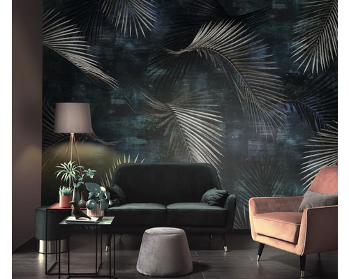 Wohnzimmer mit Sofa, Sessel und einer Wandtapete mit Palmenmuster für eine gemütliche Atmosphäre.