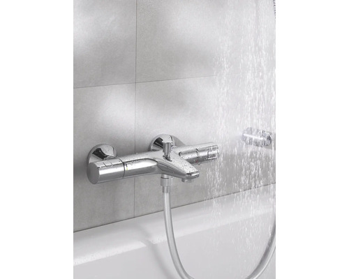 Robinet de baignoire apparent avec flexible de douche et eau courante.