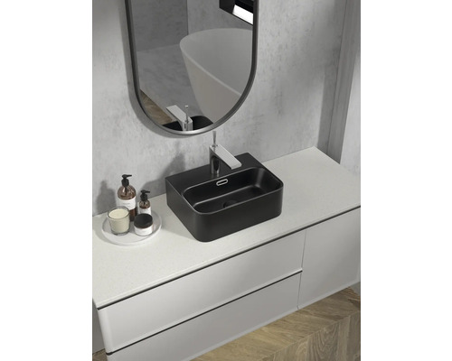 Salle de bains moderne avec lavabo à poser noir, miroir et meuble sous-lavabo pour une ambiance élégante.