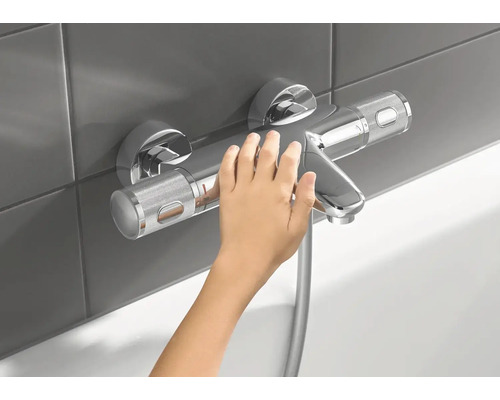 Mitigeur de douche apparent avec une main d''enfant dans la salle de bain