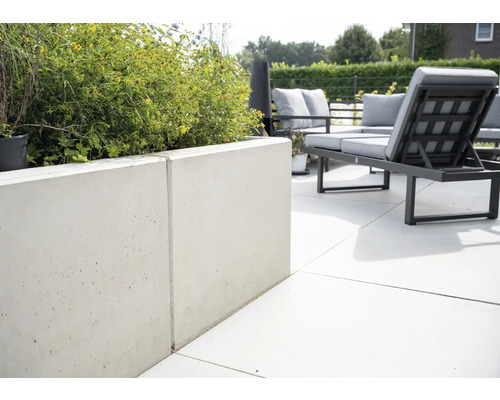 Terrasse mit Betonmauer und Gartenmöbeln