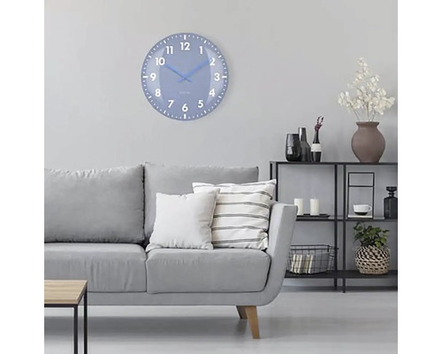 Wohnzimmer mit grauer Couch, Regal und einer runden Wanduhr mit Ziffernblatt