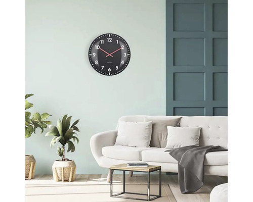 Salon avec horloge murale, canapé et table d''appoint