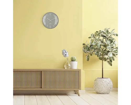 Wohnzimmer mit Anrichte, Zimmerpflanzen und einer Wanduhr