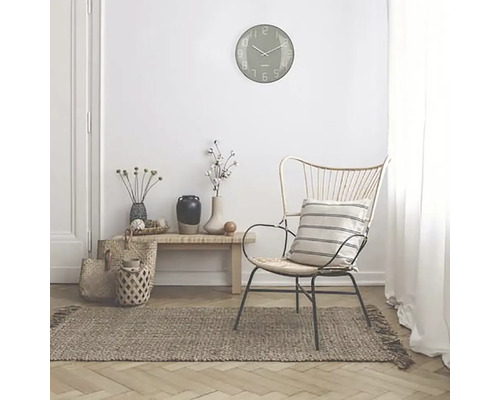 Innenraumszene mit einer Wanduhr, einem Stuhl, einem Teppich und dekorativen Accessoires für eine gemütliche Atmosphäre