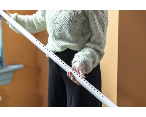 Eine Person hält ein weisses Rohr mit Löchern.