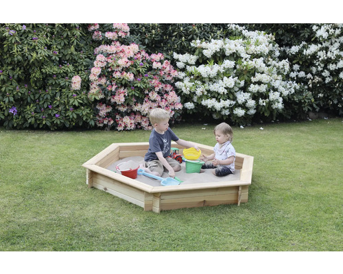 Bac à sable en bois dans le jardin avec des enfants qui jouent