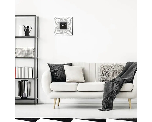 Wohnzimmer mit Regal, Sofa, Kissen und einer quadratischen Wanduhr