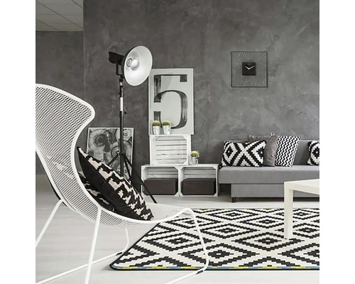 Modernes Wohnzimmer mit Sofa, Sessel, Teppich und Dekoration in Grautönen