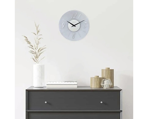 Dekorative Wanduhr über einer Kommode mit Wohnaccessoires