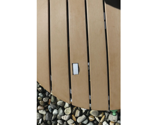 Detailansicht eines Whirlpools mit Holzverkleidung und Steinen.