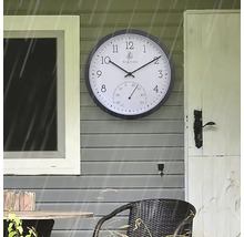 Aussenaufnahme einer Wanduhr mit Thermometer an einer Hauswand