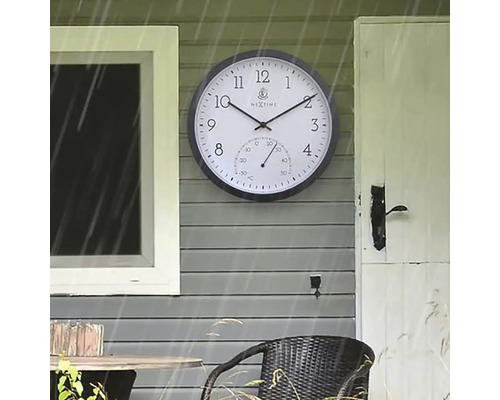 Aussenaufnahme einer Wanduhr mit Thermometer an einer Hauswand