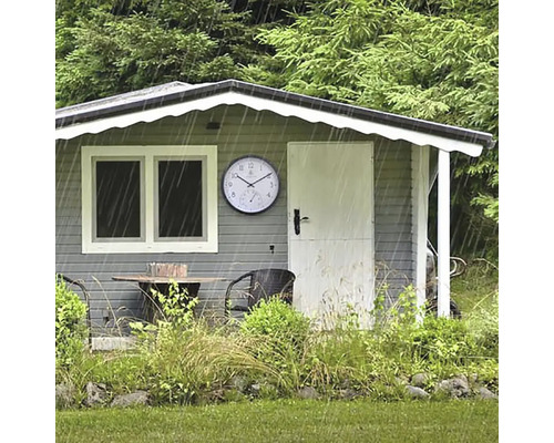 Gartenszene mit Gartenhaus, Gartenmöbeln und einer Wetterstation im Regen