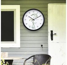 Wanduhr mit Kräutermotiv an einer Fassade