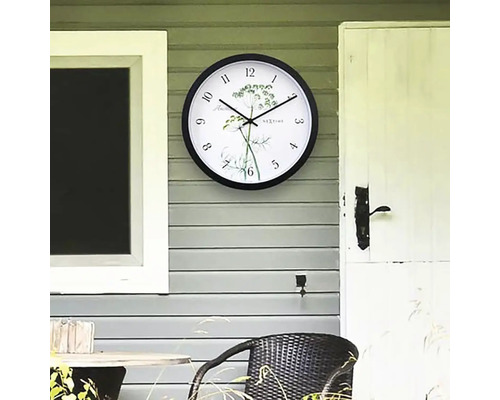 Wanduhr mit Kräutermotiv an einer Fassade