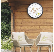 Gartenszene mit Wanduhr, Stühlen und Kissen