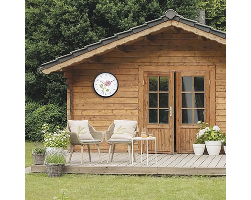 Holzgartenhaus mit Wanduhr und Sitzbereich auf der Terrasse