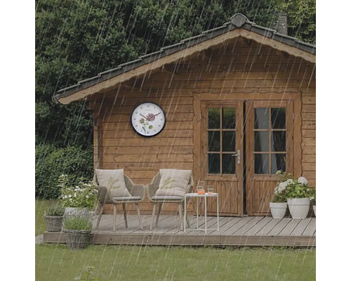 Gartenhaus mit Wanduhr im Regen, Stühlen und Tisch