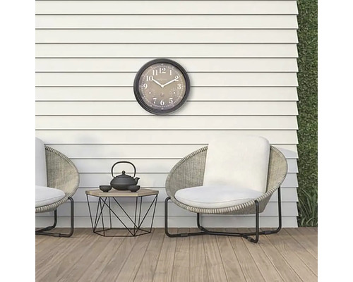 Szene mit Outdoor-Uhr, Stühlen und einem kleinen Tisch mit Teekanne