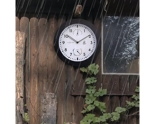 Wanduhr mit Thermometer und Hygrometer an einer Holzwand im Regen
