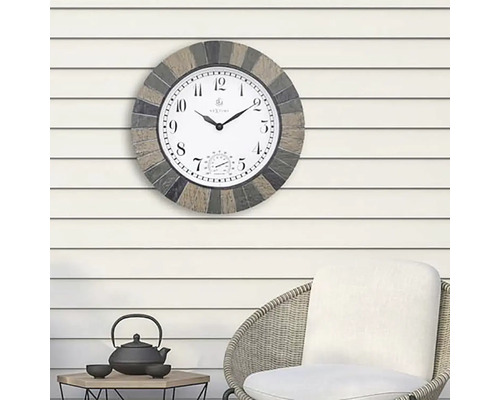 Horloge d''extérieur avec thermomètre sur un mur au-dessus d''une chaise et d''une table.