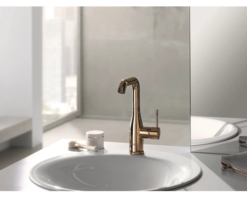 Robinet de lavabo doré sur un lavabo dans une salle de bain.