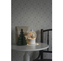 Arrangement décoratif avec boule à neige, cadeau et arbre en papier sur une table