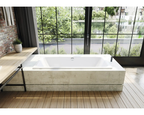 Freistehende Badewanne in einem hellen Badezimmer mit Blick auf die Natur