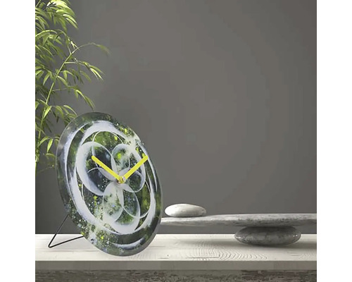 Horloge de table avec motif floral abstrait et aiguilles jaunes sur une table
