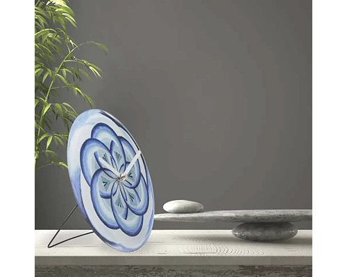 Horloge de table décorative avec motif floral bleu sur une table