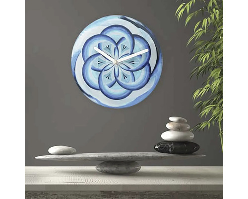 Horloge murale avec motif floral bleu à côté d''une pile de pierres
