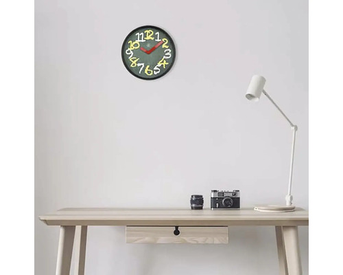 Horloge murale avec chiffres sur un bureau avec lampe et appareil photo