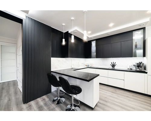 Moderne Küche mit schwarzen Schränken, weißer Arbeitsplatte und zwei Barhockern.