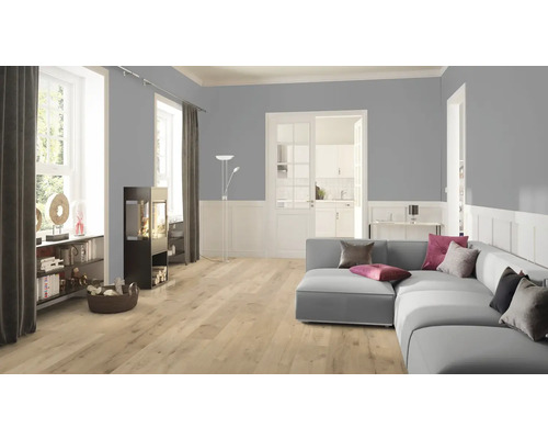 Wohnzimmer mit Sofa, Kaminofen und hellem Laminatboden.