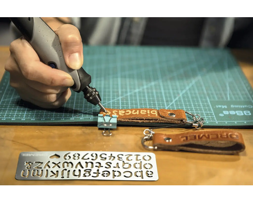 Outil de gravure Dremel gravant un porte-clés en cuir avec le nom Bianca, modèle pour lettres et chiffres sur l''image