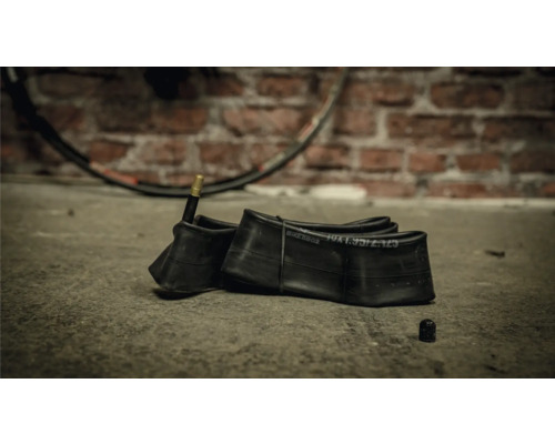 Fahrradschlauch mit Ventil vor Ziegelwand