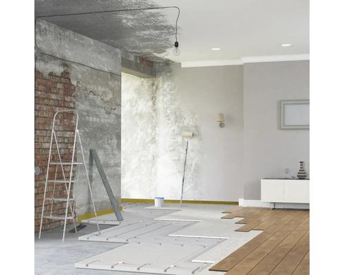 Renovierungsarbeiten in einem Raum mit Heizung, Leiter und Werkzeugen.