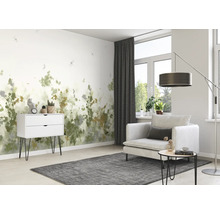 Salon avec papier peint à motifs, fauteuil et commode pour une ambiance lumineuse et conviviale