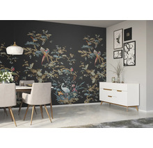 Ein Esszimmer mit Esstisch, Stühlen, Sideboard und einer Wand mit einer Tapete mit Vogel- und Pflanzenmotiven
