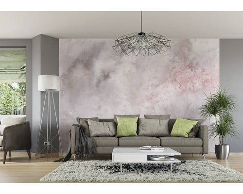 Wohnzimmer mit Sofa, Teppich, Lampe und Zimmerpflanze