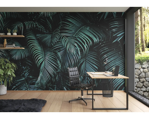 Arbeitszimmer mit einer Fototapete mit tropischen Palmenblättern, einem Schreibtisch, einem Bürostuhl und Regalen
