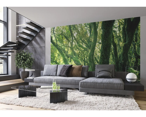 Salon moderne avec papier peint photo à motif de forêt, canapé, table et escalier.